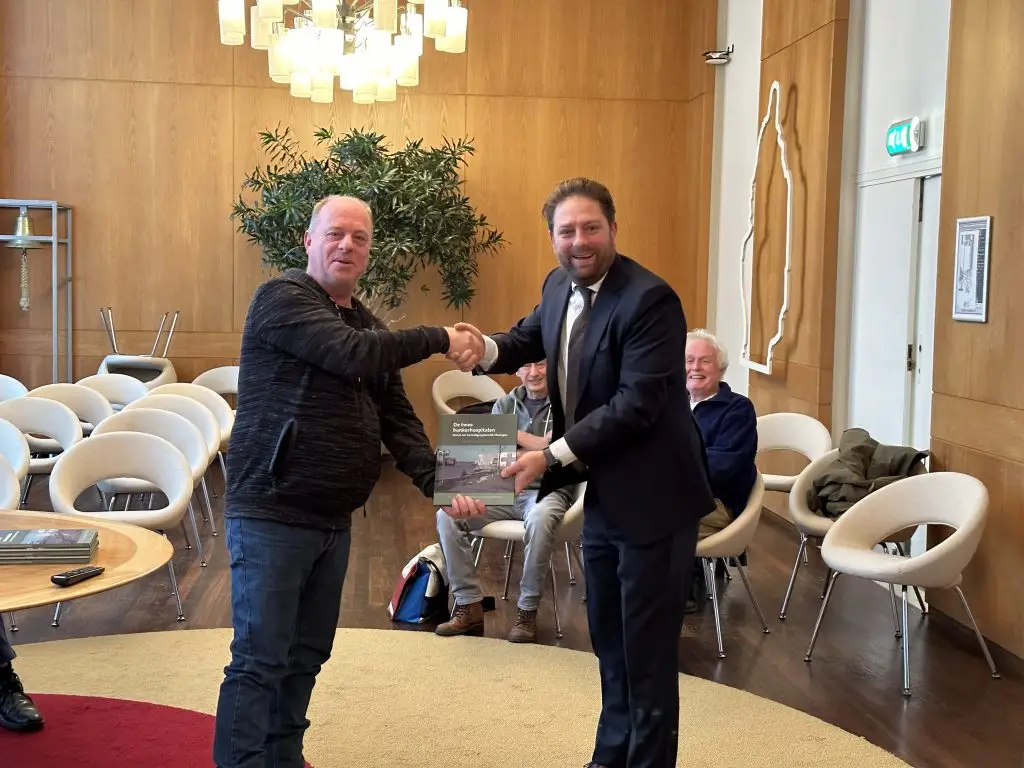 Overhandiging van het boekje De Twee Bunkerhospitalen aan de wethouder in het stadskantoor van Vlissingen.